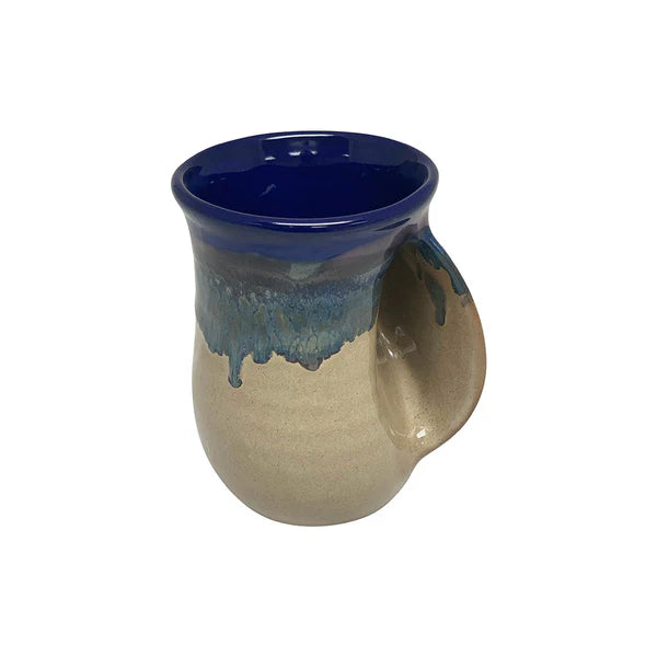 Handcrafted ceramic handwarmer mug with a deep cobalt blue rim and natural beige body, designed for cozy tea sipping during chilly days.