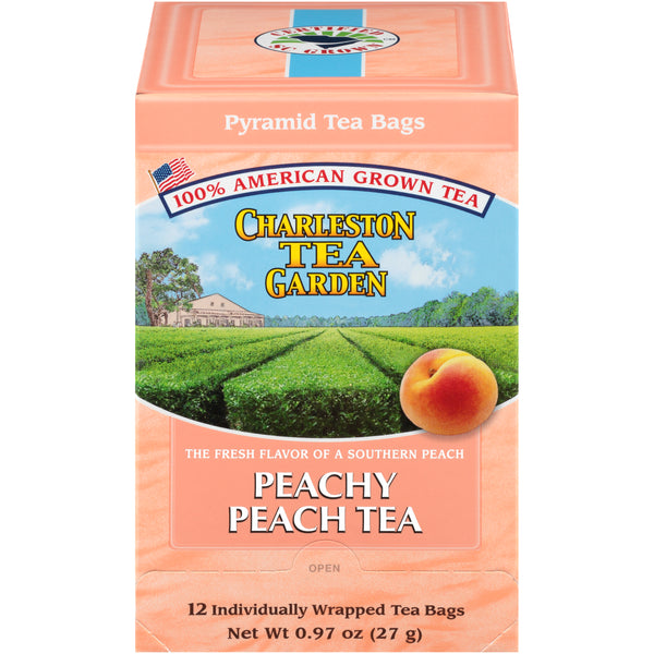 Box of peach-flavored pyramid tea bags from Charleston Tea Garden, featuring an image of lush green tea fields and a ripe peach on a soft peach-colored background.