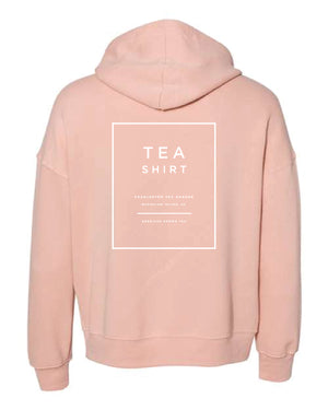 Back view of a soft peach fleece hoodie featuring a minimalist white box design promoting Charleston Tea Garden and American Classic Tea, perfect for casual wear or souvenirs.