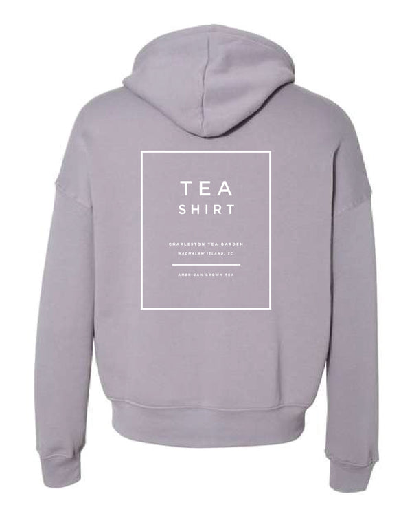 Light gray fleece hoodie with a simple back design featuring text related to Charleston Tea Garden and American brown tea, perfect for comfortable casual wear.