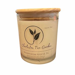 Glass jar candle with a wooden lid, featuring a sweet tea scent and labeled with Charleston Tea Garden from Wadmalaw Island, South Carolina.