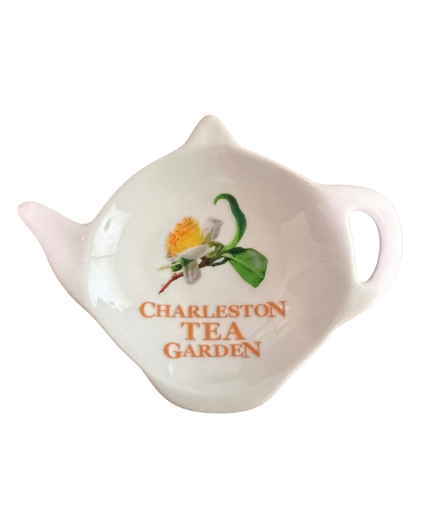 White ceramic tea caddy shaped like a teapot with a floral design and the words Charleston Tea Garden printed on it, perfect for tea lovers and souvenirs.