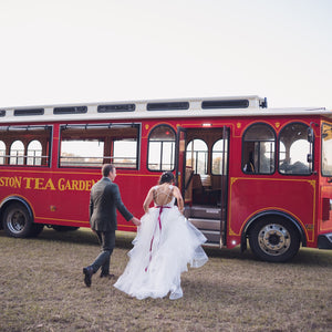 An image of a couple going into a trolley at Charleston Tea Garden, a Charleston wedding venue and tea farm in South Carolina. 