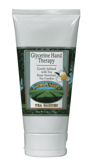 White tube of glycerine hand therapy cream infused with tea from Charleston Tea Garden, featuring a scenic tea field label and a small flower illustration.