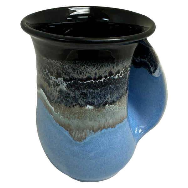 Ceramic handwarmer mug with a black and blue glaze featuring a smooth, curved handle, perfect for cozying up with your favorite hot drink.
