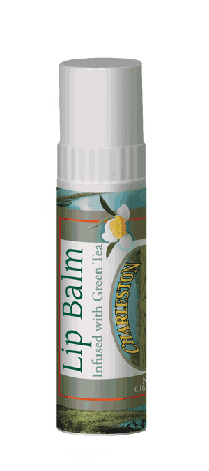 Close-up of a lip balm tube with green tea infusion, featuring a white flower illustration and a label highlighting its connection to Charleston Tea Garden.