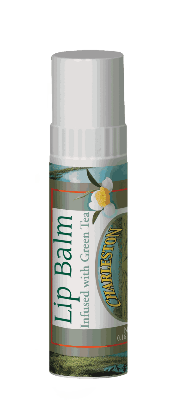 Close-up of a lip balm tube with green tea infusion, featuring a white flower illustration and a label highlighting its connection to Charleston Tea Garden.