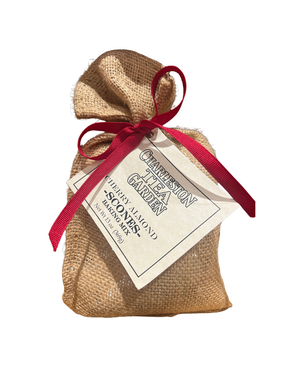 Small burlap bag tied with a red ribbon featuring a label for Charleston Tea Garden Cherry Almond Scone Mix, giving a rustic and charming gift appearance.