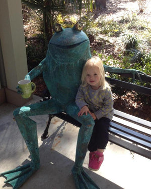 An image of a little girl ith Waddy the frog at a tea plantation in Charleston. 