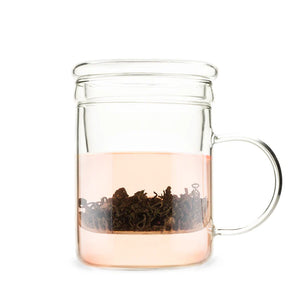 Clear glass mug with a built-in tea infuser steeping loose leaf tea, showcasing the warm pinkish hue of the brew.