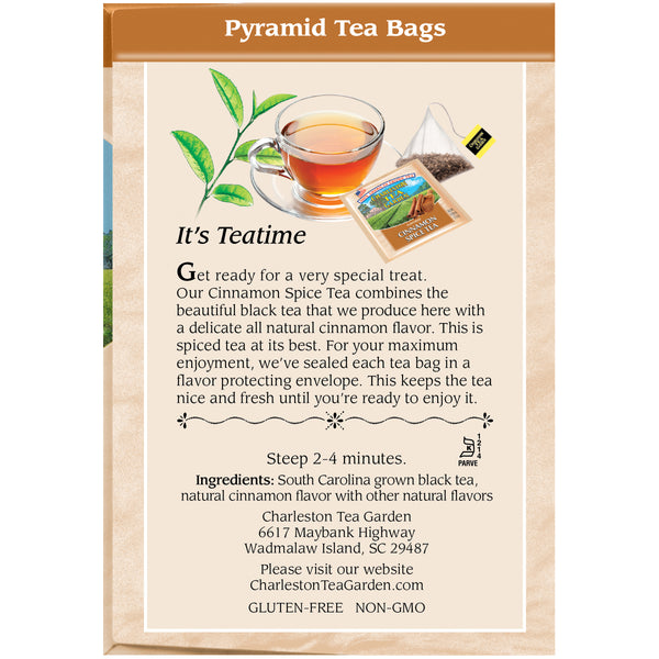 Close-up of a pyramid-shaped tea bag filled with black tea, a clear cup of brewed cinnamon spice tea, and a package label featuring natural cinnamon flavor from Charleston Tea Garden.