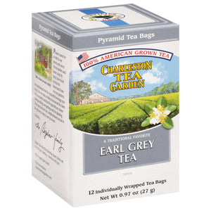 Box of individually wrapped pyramid tea bags featuring Charleston Tea Garden’s 100% American grown Earl Grey tea with a scenic tea field illustration.
