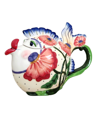 Colorful ceramic teapot shaped like a whimsical fish with floral patterns, vivid red lips, blue fins, and a green handle, perfect as a charming tea accessory or souvenir.