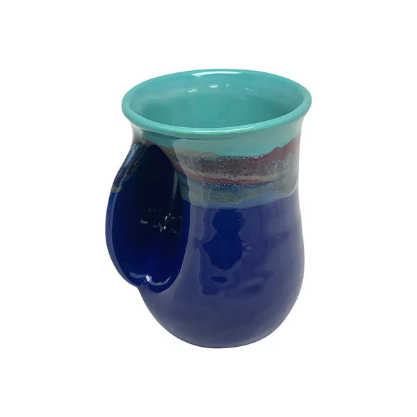 Ceramic handwarmer mug in deep blue and turquoise glaze with a curved pocket to warm hands while enjoying a hot beverage.