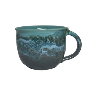 Handcrafted ceramic latte mug with a textured riverstone glaze in soothing blue and green tones, perfect for enjoying a warm cup of tea or coffee.