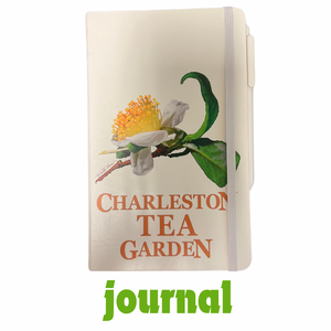 Journal with a detailed illustration of a tea flower and green leaves, featuring the words Charleston Tea Garden on the cover and a white elastic band closure.