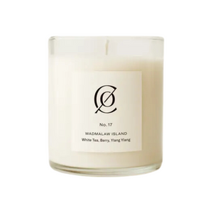 White candle in a clear glass container with a minimalist label reading No. 17 Wadmalaw Island, scented with white tea, berry, and ylang-ylang, evoking the charm of Charleston Tea Garden.