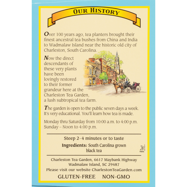 Informative sign explaining the history of tea bushes brought from China and India to Wadmalaw Island, South Carolina, and details about tours at the Charleston Tea Garden.