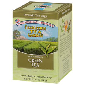 Box of pyramid-shaped green tea bags from Charleston Tea Garden featuring American-grown tea and a scenic tea field illustration on the packaging.