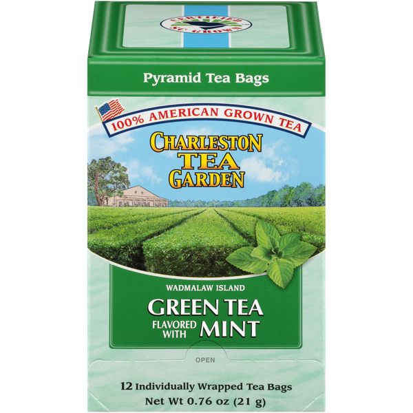 Box of Charleston Tea Garden green tea with mint flavor, featuring pyramid-shaped tea bags and imagery of lush tea fields under a blue sky.