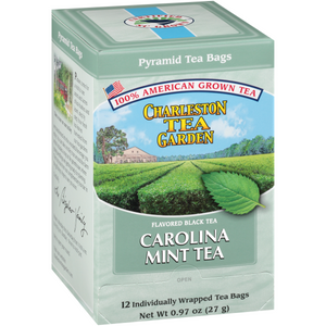 Box of Carolina Mint Pyramid tea bags featuring American-grown black tea from Charleston Tea Garden with a scenic illustration of lush tea fields and a fresh mint leaf.