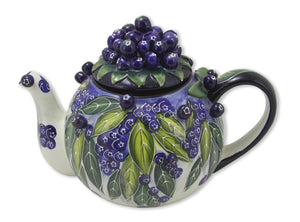 Hand-painted ceramic teapot decorated with vibrant blueberries and green leaves, featuring a cluster of blueberries on the lid and a comfortable handle.