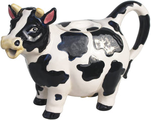 Ceramic teapot designed to look like a black and white cow, featuring detailed ears, horns, and a tail-shaped handle for a charming tea experience.