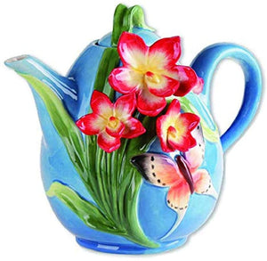 Colorful ceramic teapot with vibrant red and yellow dogwood flowers and a delicate butterfly design on a bright blue background, perfect for tea lovers.