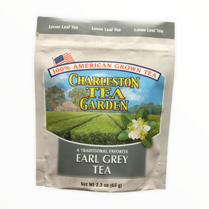 Pouch of loose leaf Earl Grey tea from Charleston Tea Garden with American flag, green tea fields, and tea blossoms on the packaging.