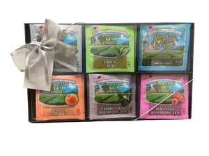 Assorted tea gift set featuring colorful packets of green, peach, breakfast, and raspberry teas, presented with a decorative fabric bow.