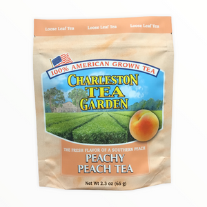 A pouch of Charleston Tea Garden's peach-flavored loose leaf tea featuring a southern peach illustration and emphasizing 100% American grown tea.