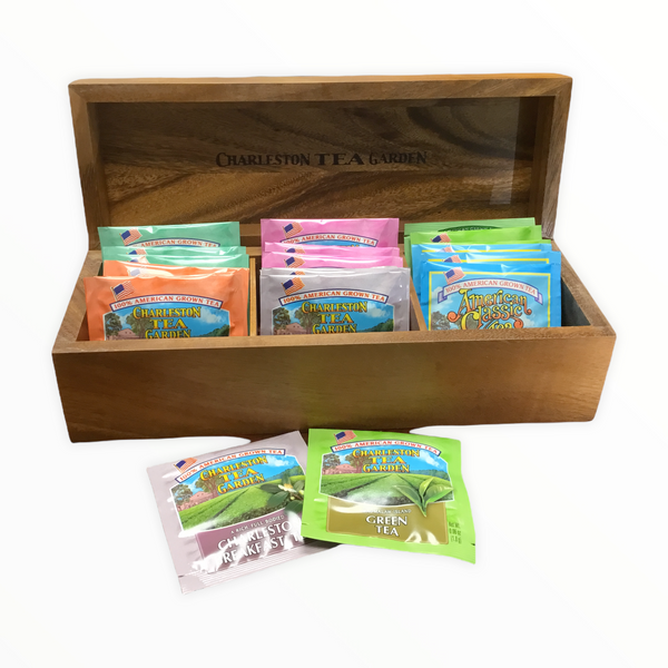Open wooden tea chest filled with colorful assorted tea bags from Charleston Tea Garden, showcasing a variety of American Classic Tea blends in a decorative display.